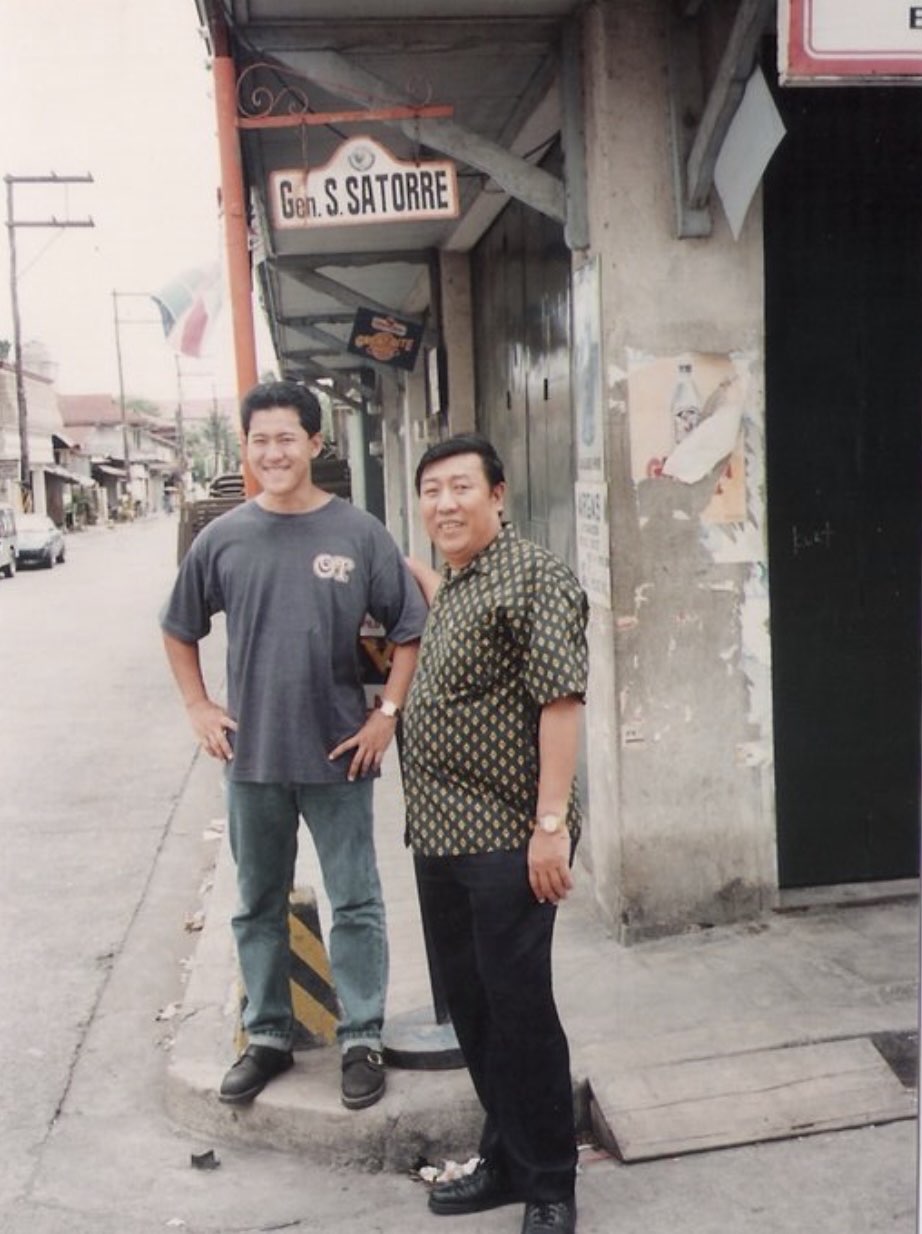 Maning near a Gen. S. Satorre street sign with another person